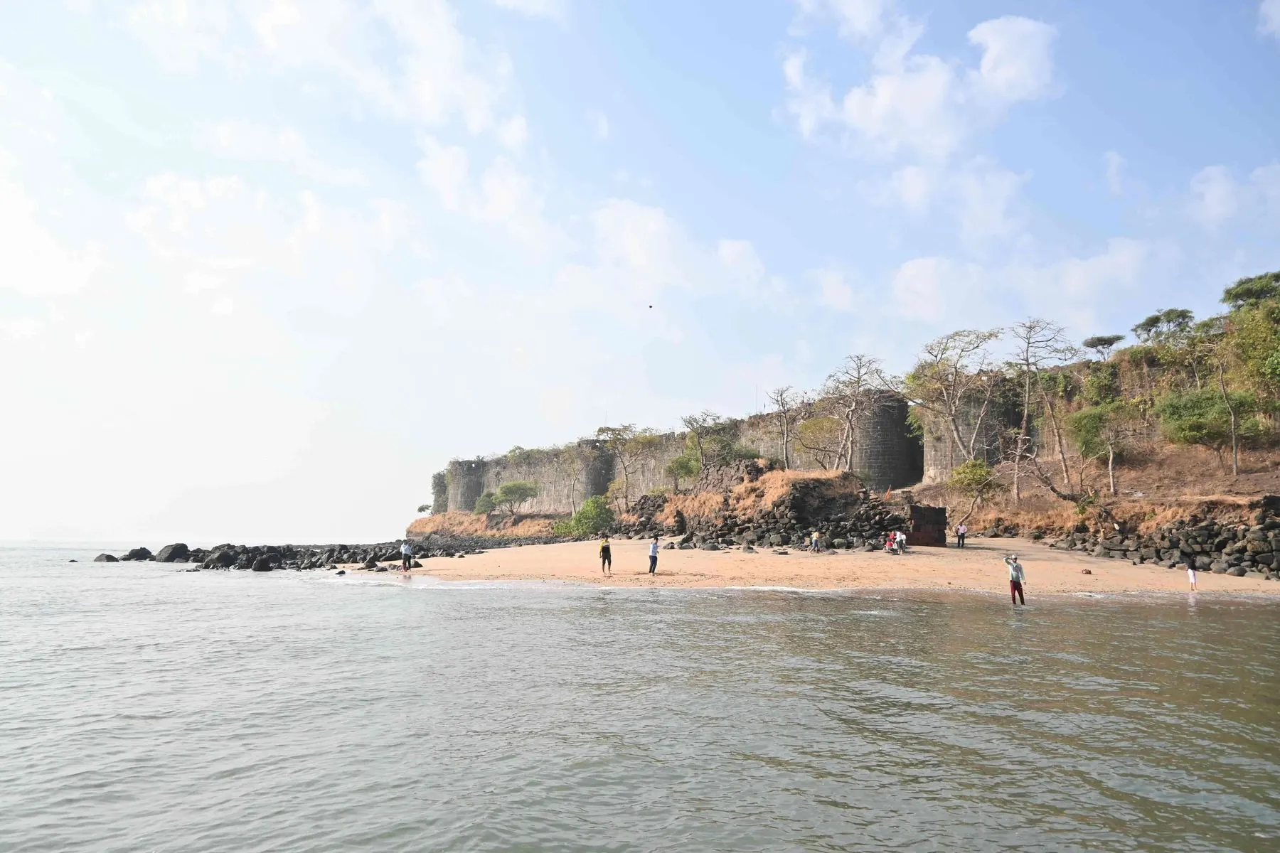 Harnai Beach shoreline with the stone walls of Kanakdurg fort
